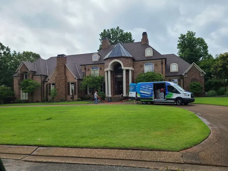 HydroClean van parked in the driveway of a brick home during a job