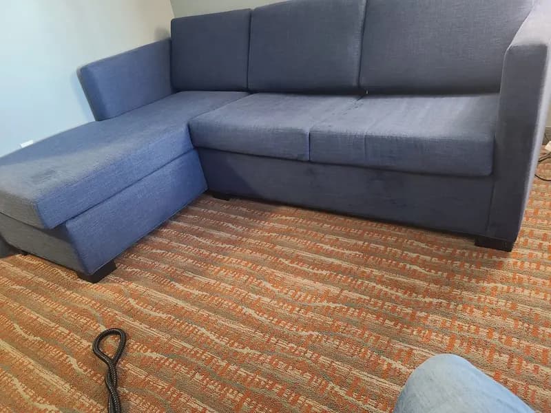 Blue sectional sofa and patterned carpet after cleaning