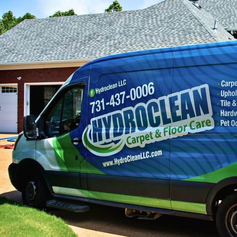 HydroClean Carpet and Floor Care van parked in the driveway of a brick home